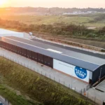 High drone shot of the North Store facility, with the sun rising over Salt Rock in the distance and the R102 in the foreground