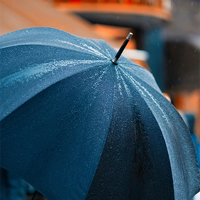 black umbrella representing insurance, covered in rain drops