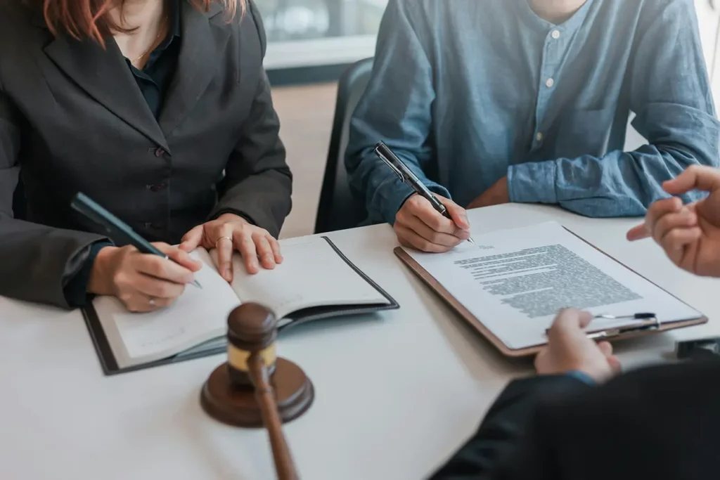 Legal documents and gavel in front of a pair of lawyers