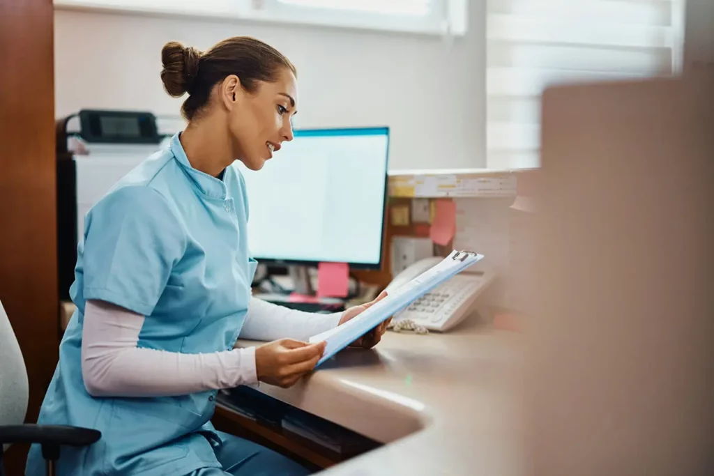 medical professional reading medical records at the reception of a hospital