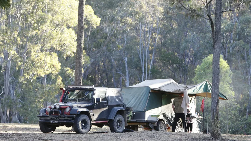 A 4x4 vehicle and tent in a beautiful outdoor setting