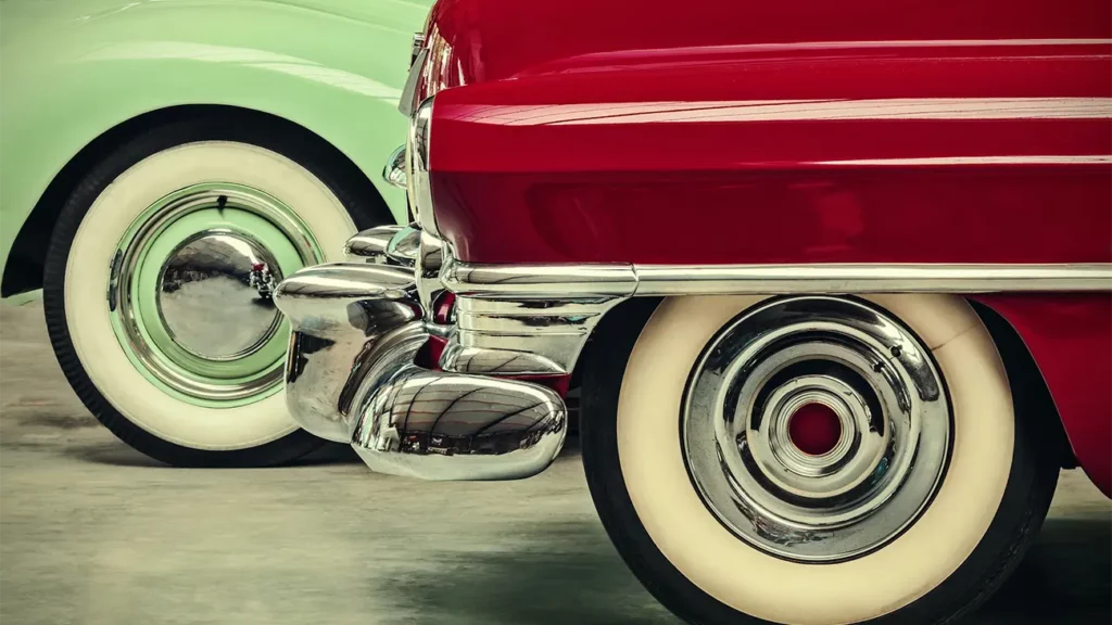 Cheery red and lime green cars, close up, with white walled tyres